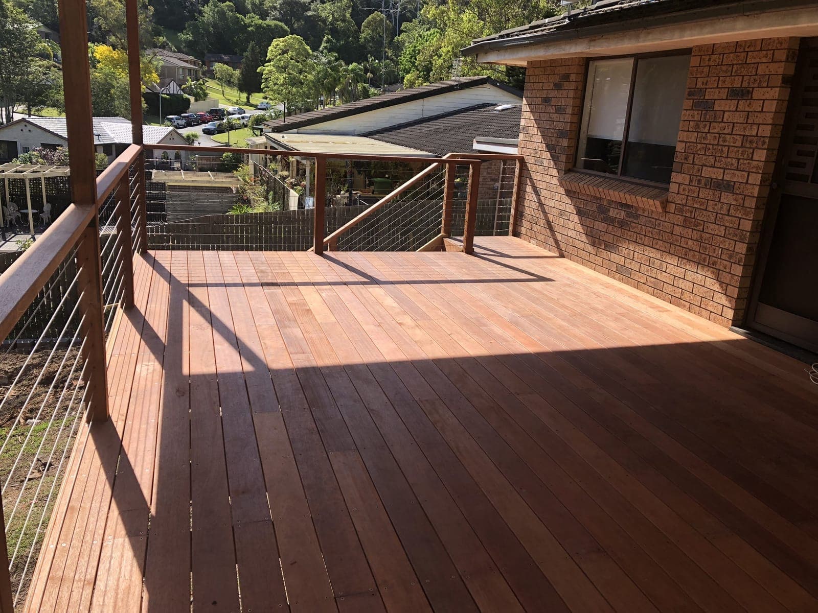 Finished elevated timber deck by Patio Empire with a leafy bushland outlook, a Central Coast NSW outdoor-living build